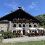 Die bewirtschaftete Erentrudisalm am Untersberg mit Sonnenschirmen im Gastgarten
