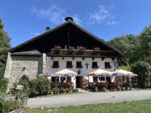Die bewirtschaftete Erentrudisalm am Untersberg mit Sonnenschirmen im Gastgarten