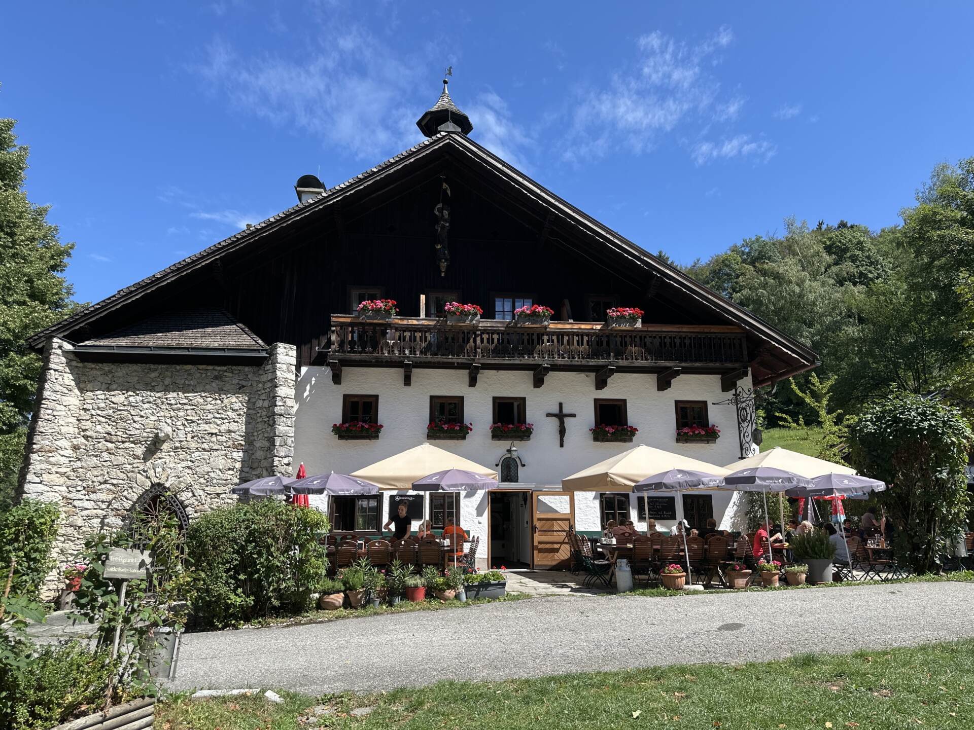 Die bewirtschaftete Erentrudisalm am Untersberg mit Sonnenschirmen im Gastgarten